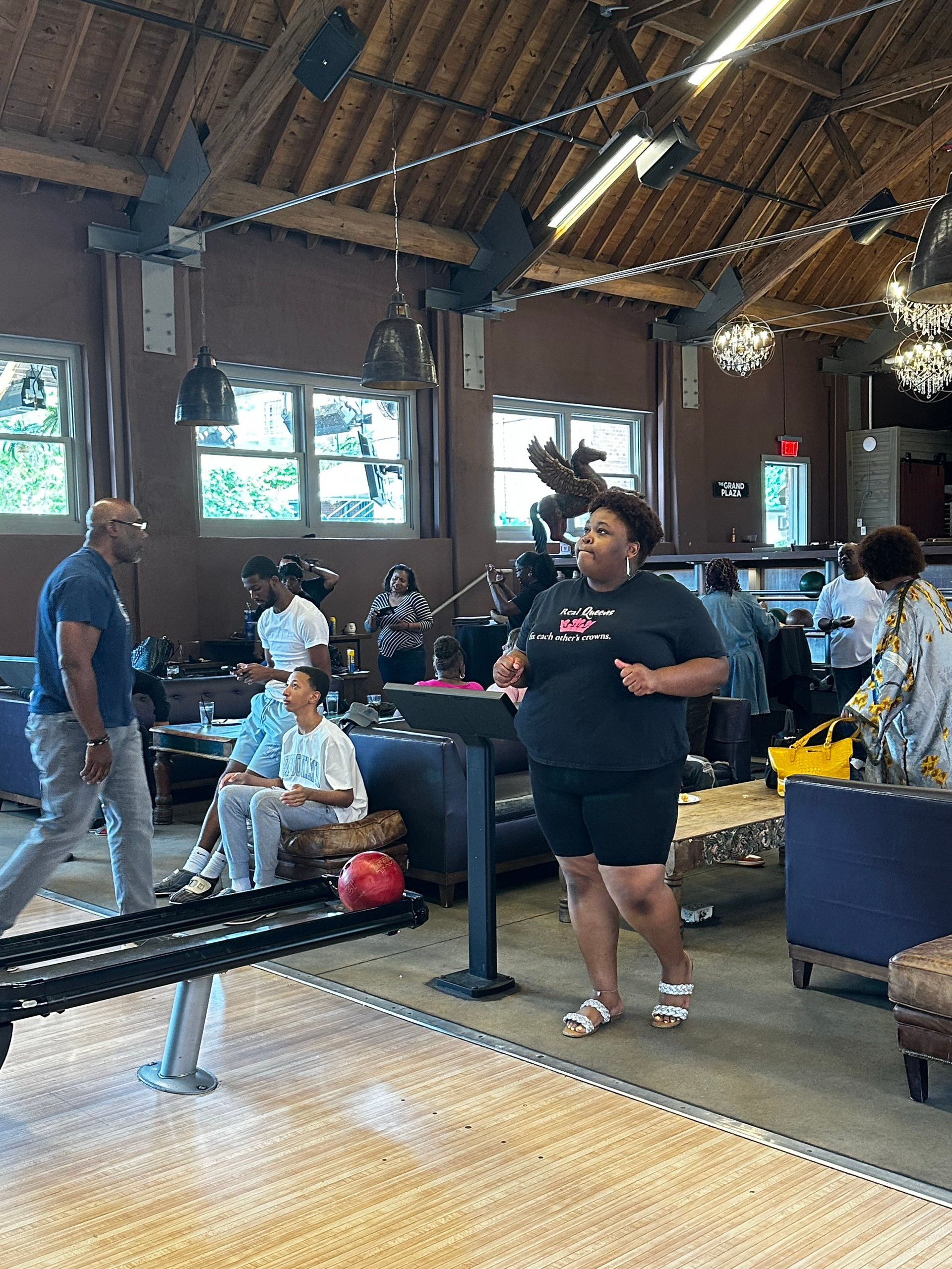 A group of people are playing bowling in a large room.