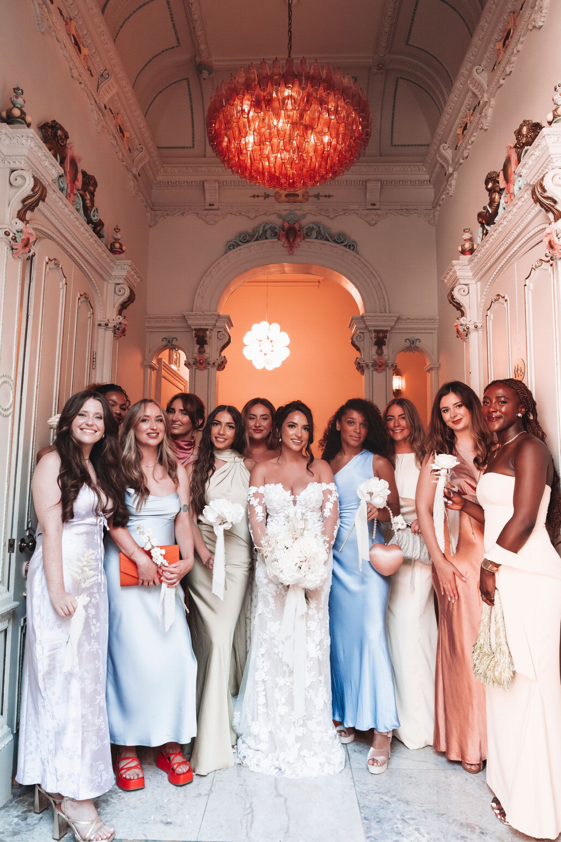 A bride and her bridesmaids are posing for a picture in a hallway.