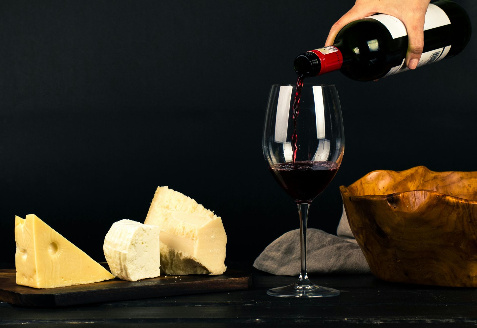 A person is pouring red wine into a glass.