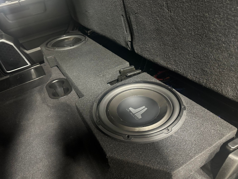 A subwoofer is sitting in the back of a car.