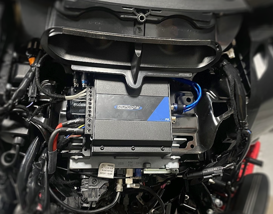 A close up of the engine of a motorcycle with the hood open.