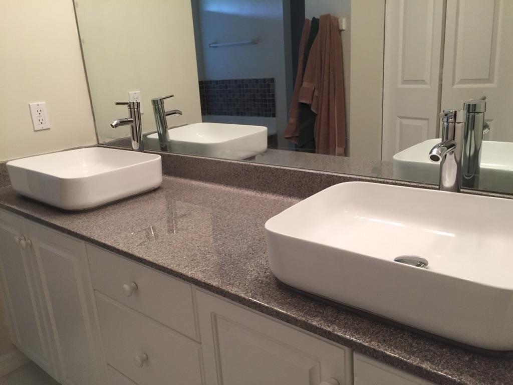 A bathroom with two sinks and a large mirror.