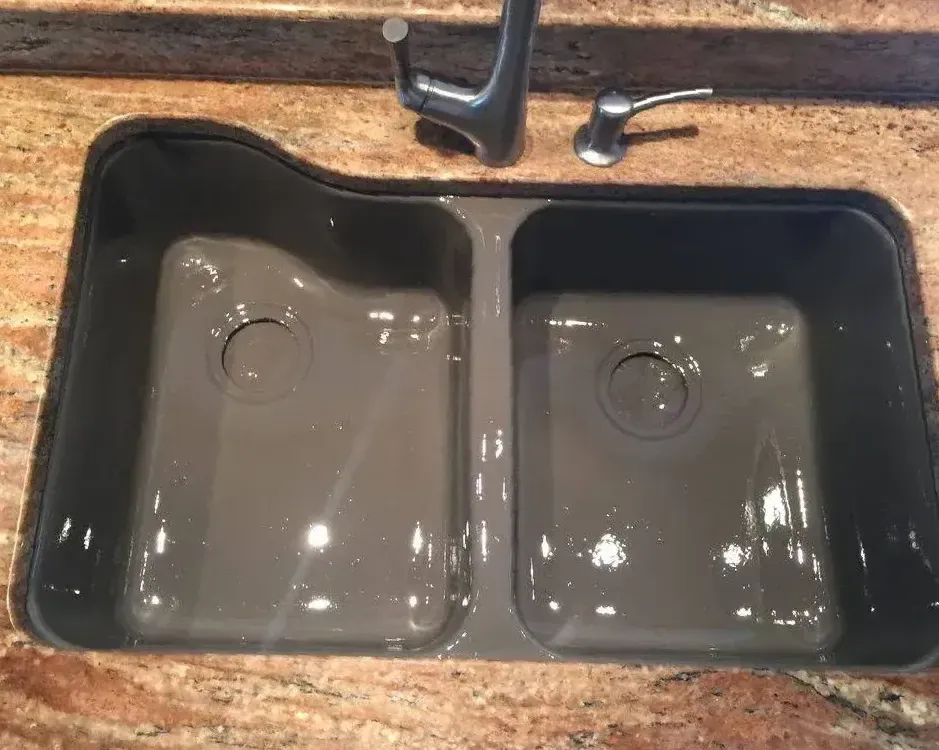 A kitchen sink is sitting on top of a granite counter.