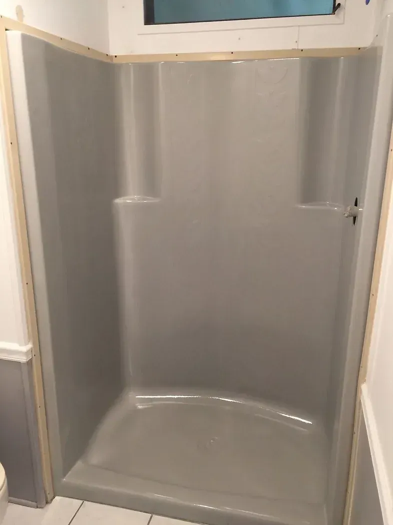 A bathroom with a shower stall and a toilet.