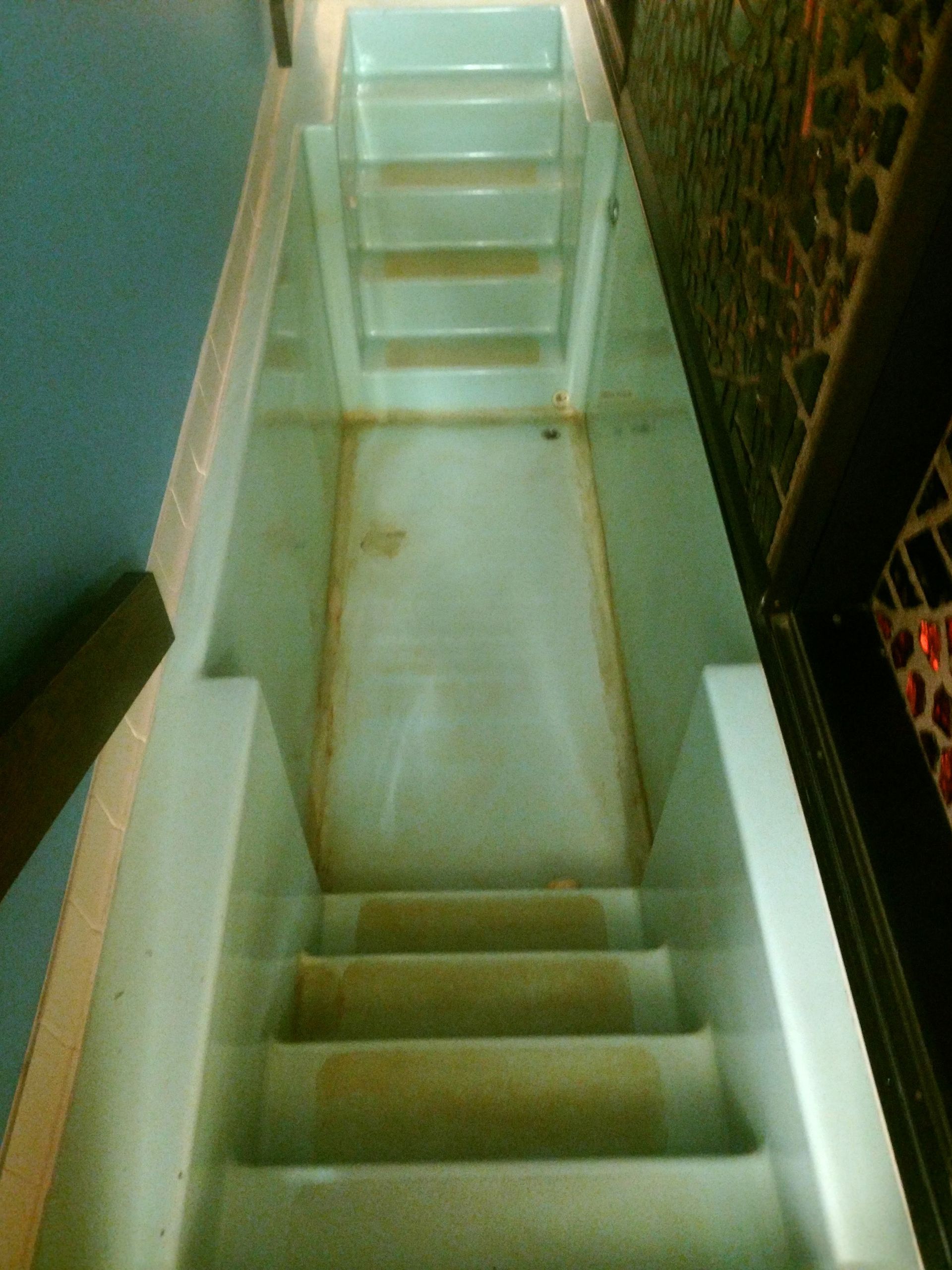 A staircase with a glass railing and a carpeted floor