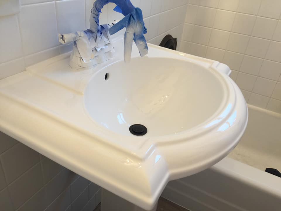 A white sink in a bathroom next to a bathtub.