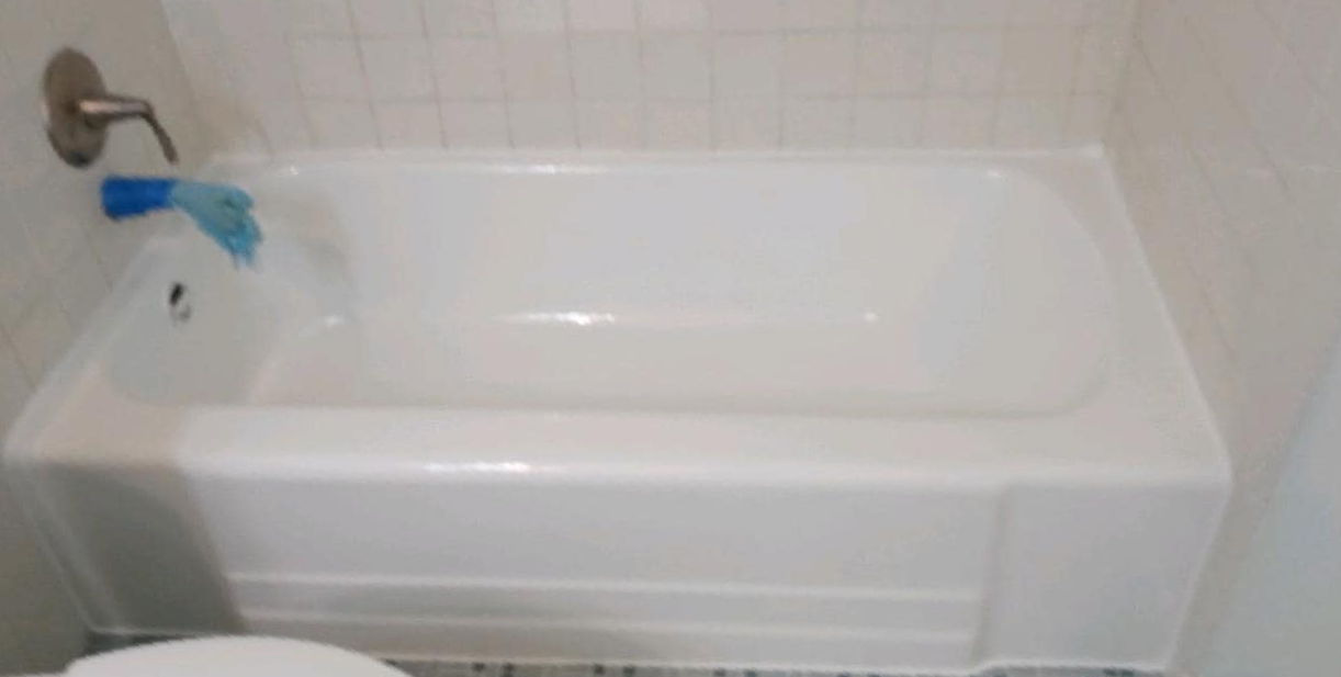 A white bathtub in a bathroom next to a toilet.
