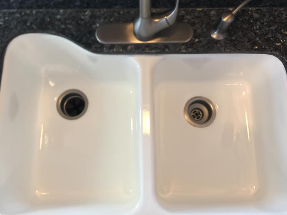 A white kitchen sink with two drains and a faucet