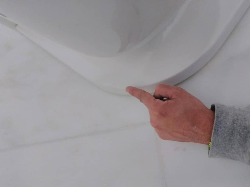 A person is holding a pen and pointing at a white wall.
