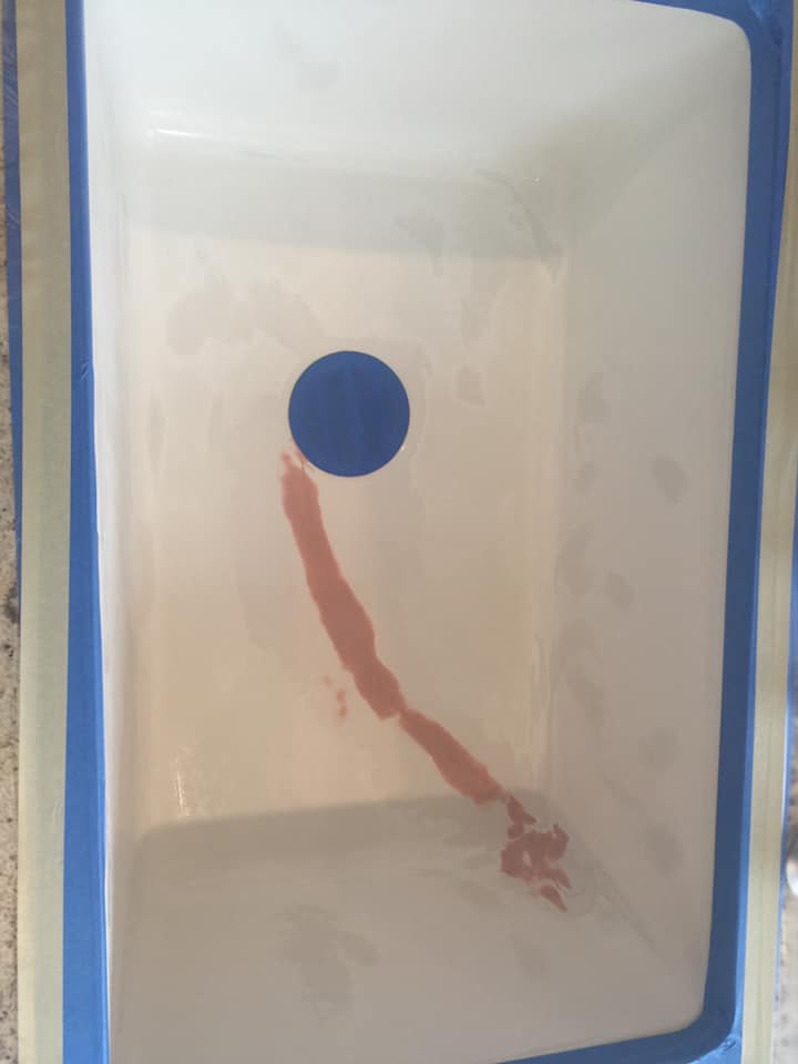 A container of water with a blue circle in the middle of it.