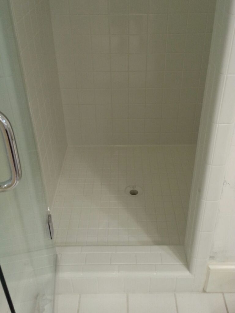 A shower stall with a glass door in a bathroom.