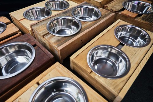 a bunch of stainless steel bowls sitting on top of wooden boxes .