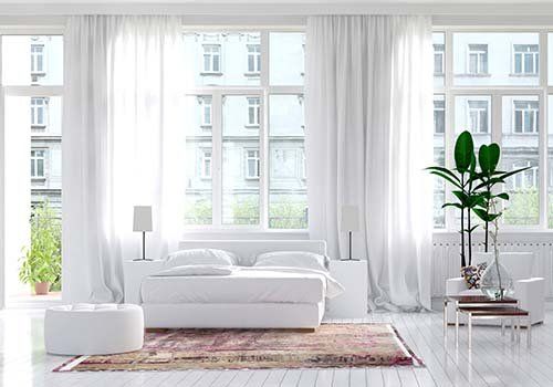 Grandi finestre in colore bianco in una camera da letto