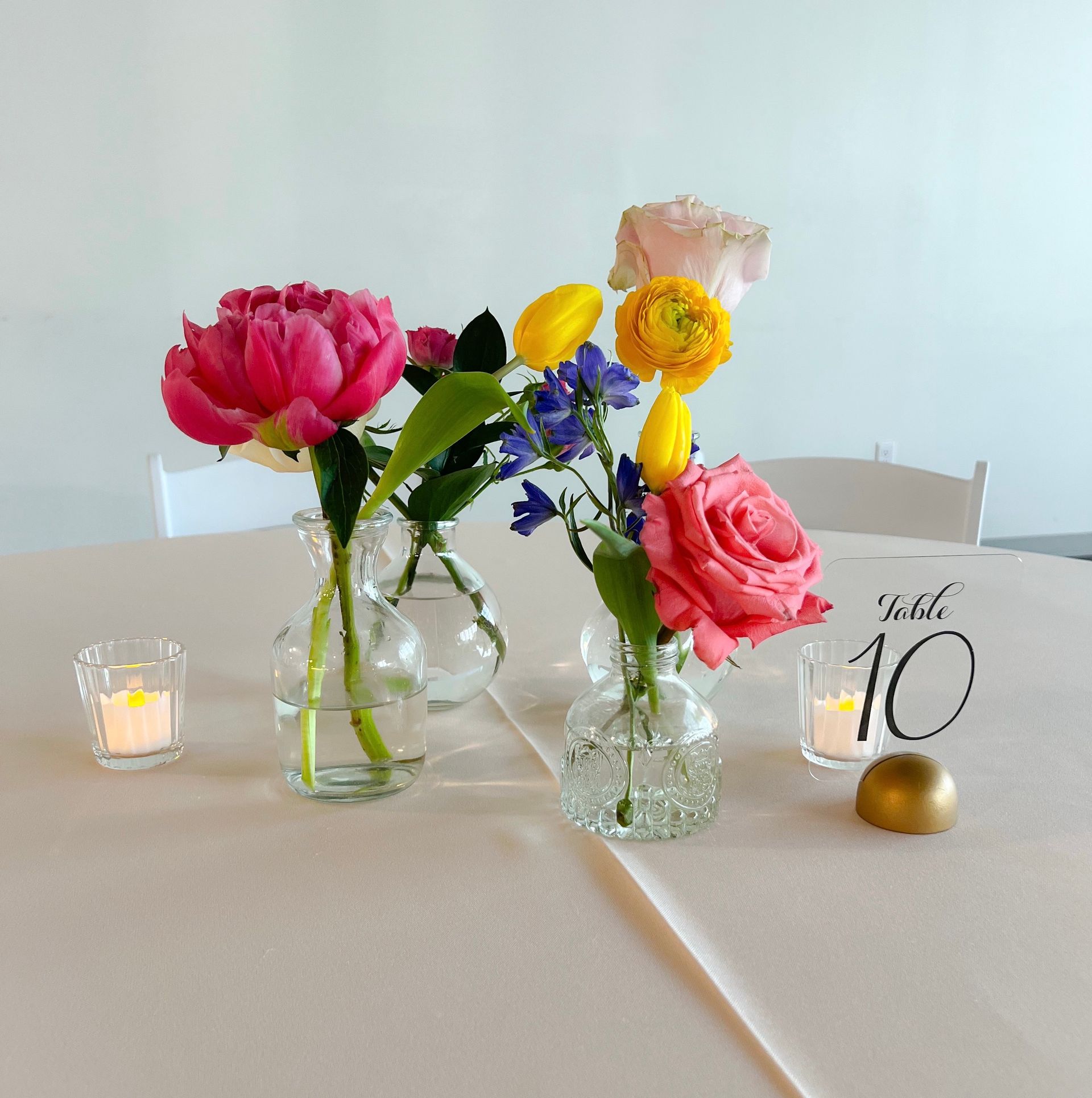 A table with vases of flowers and a table number of 10