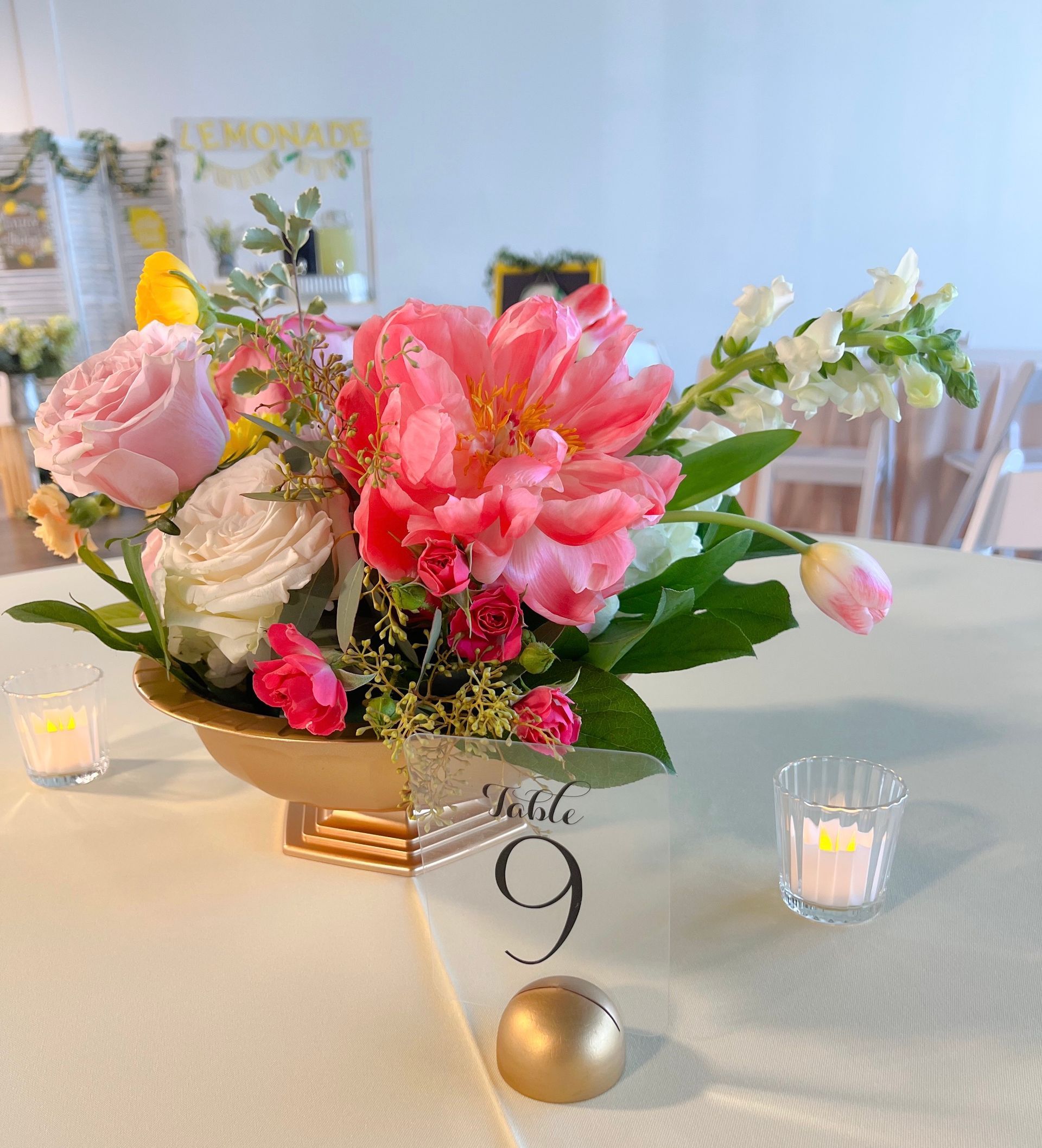 A table with a vase of pink flowers and a table number 9
