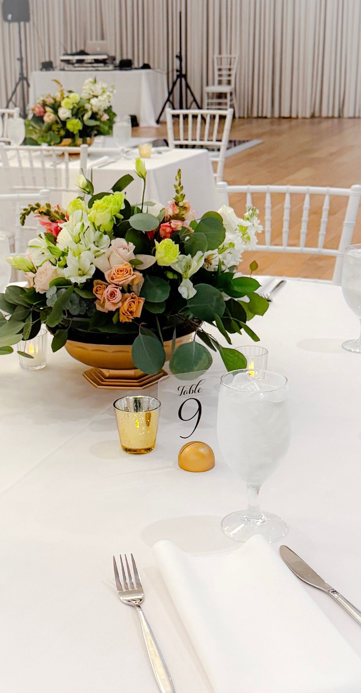 A table with a vase of flowers and candles on it.