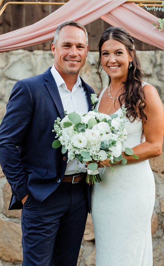 A bride and groom are posing for a picture on their wedding day.