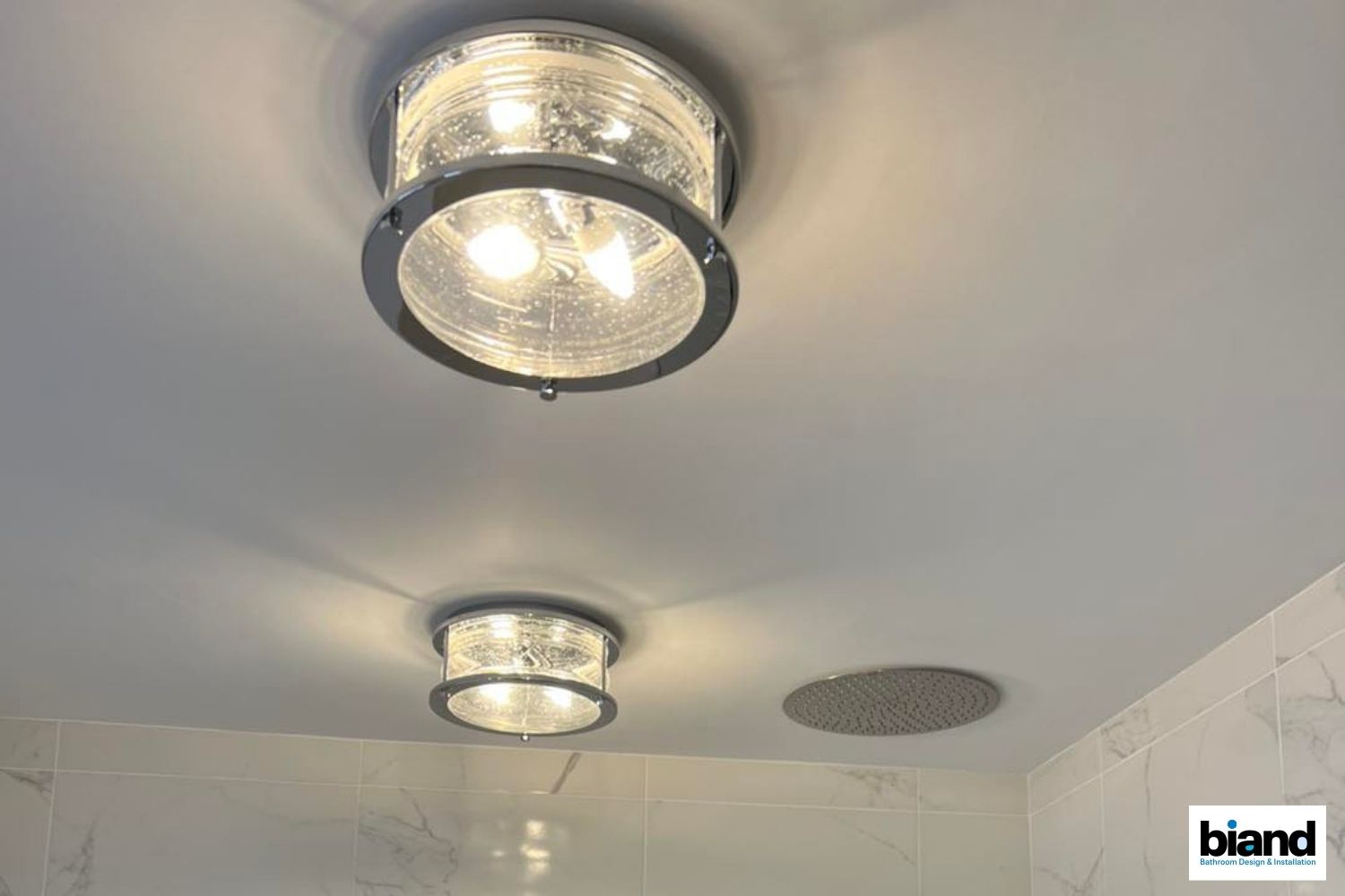 Two recessed ceiling lights with textured glass in a bathroom.