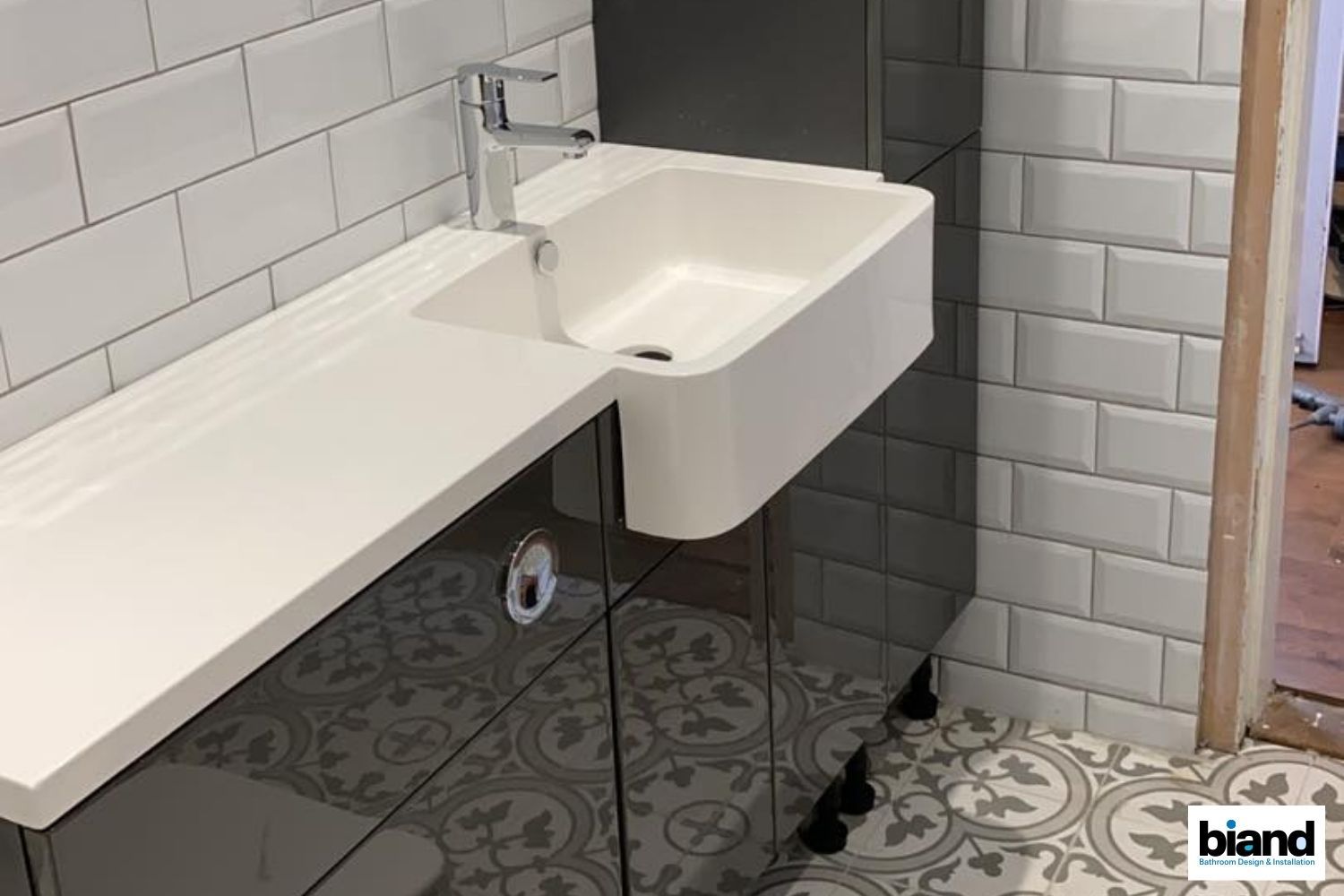 Gray bathroom vanity with white countertop, sink, and subway tiles.