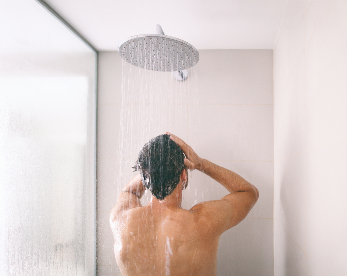 man in shower large showerhead essex