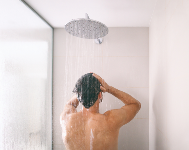 man in shower large showerhead essex