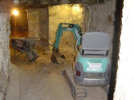mini excavator in tunnel with yellow lights