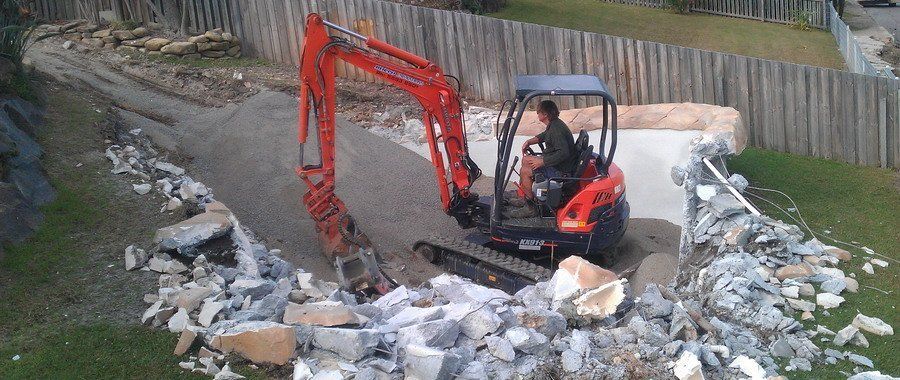 man operating orange excavator in demolished area