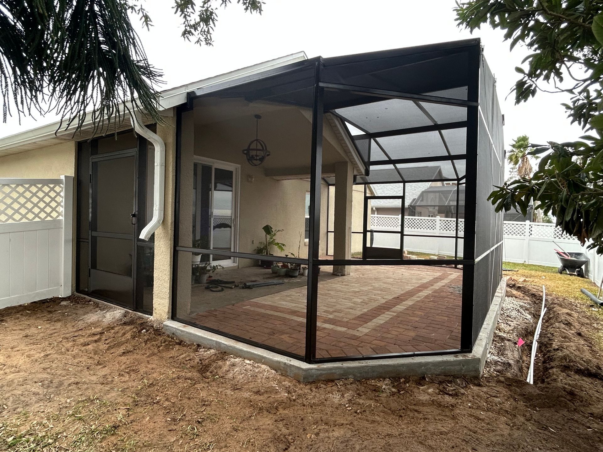 A screened in porch is being built in the backyard of a house
