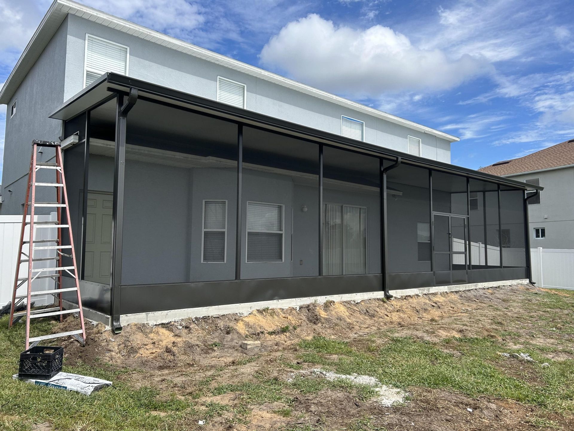 A screened in porch is being built on the side of a house