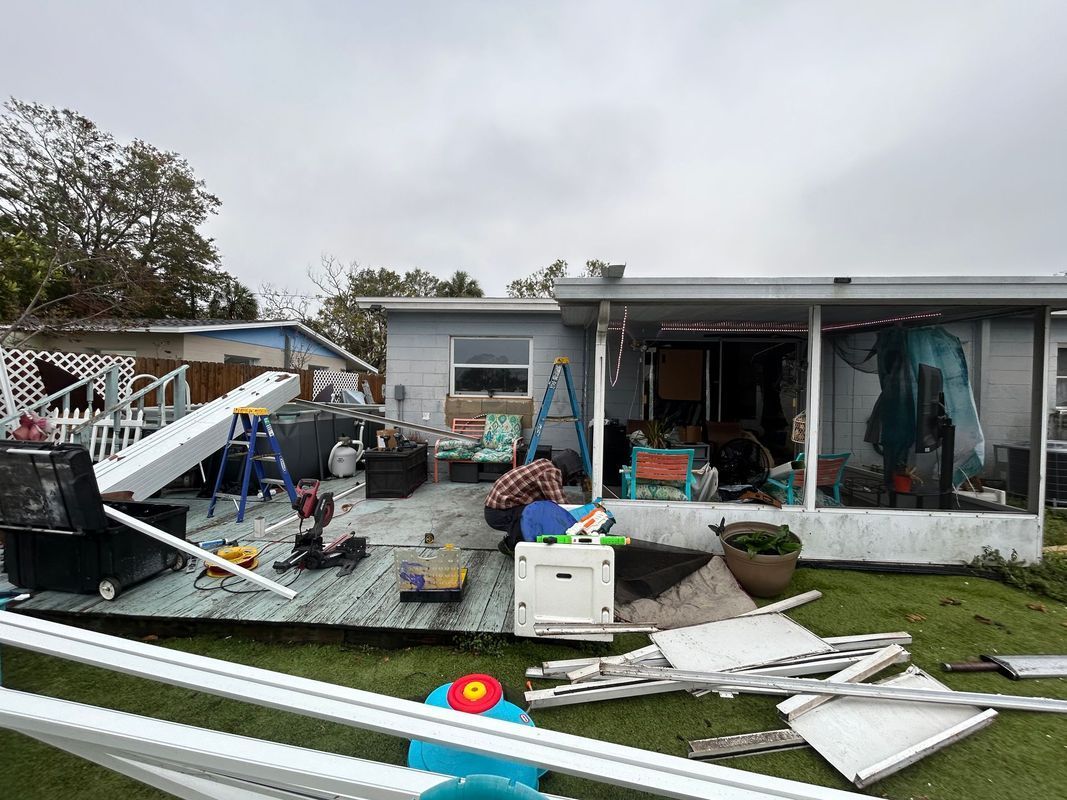 A man is working on a mobile home that has been damaged by a hurricane