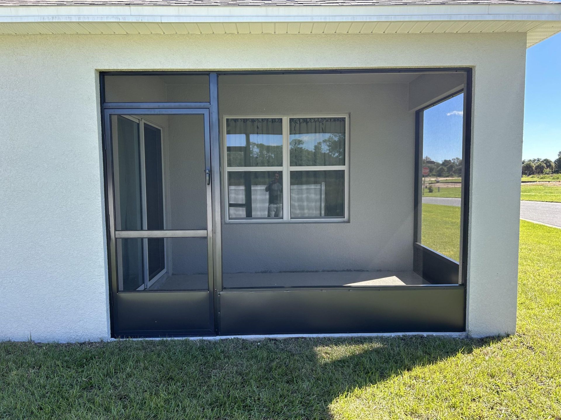 A white house with a screened in porch and a window