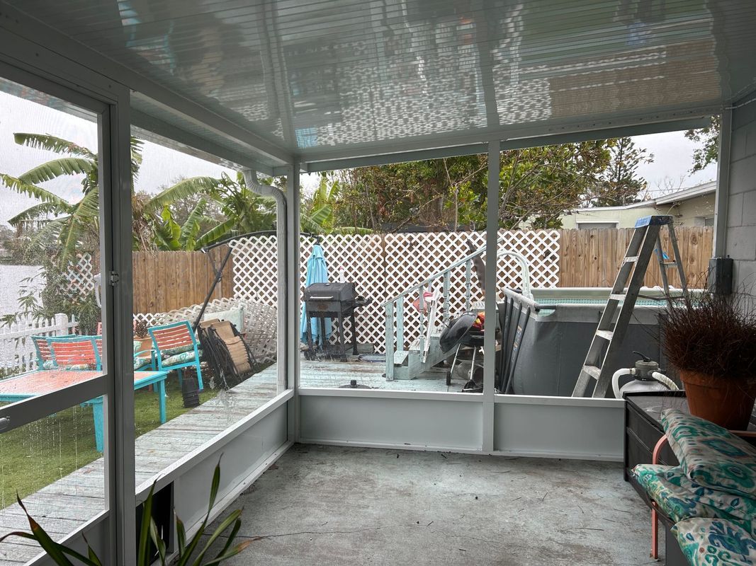 A screened in porch with a lot of windows and a ladder