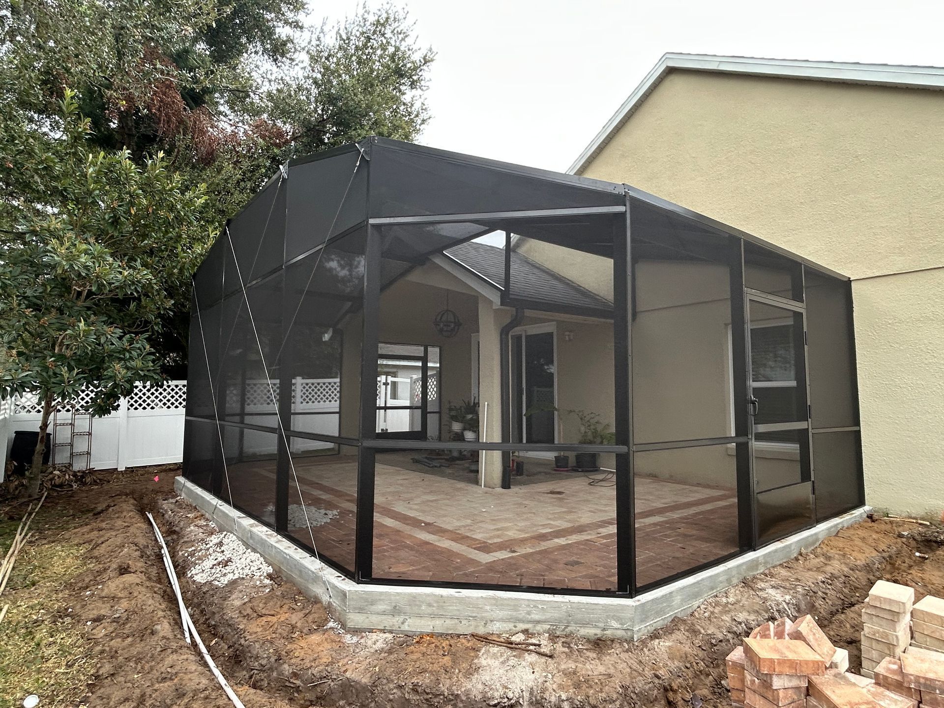 A screened in porch is being built in the backyard of a house