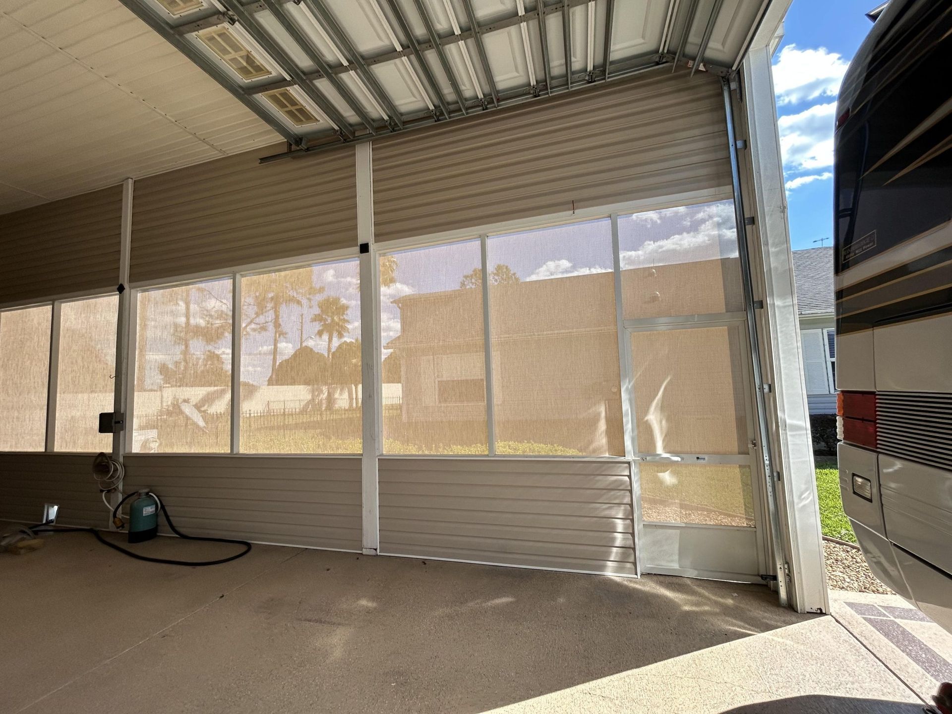A screened in porch with a rv parked inside of it
