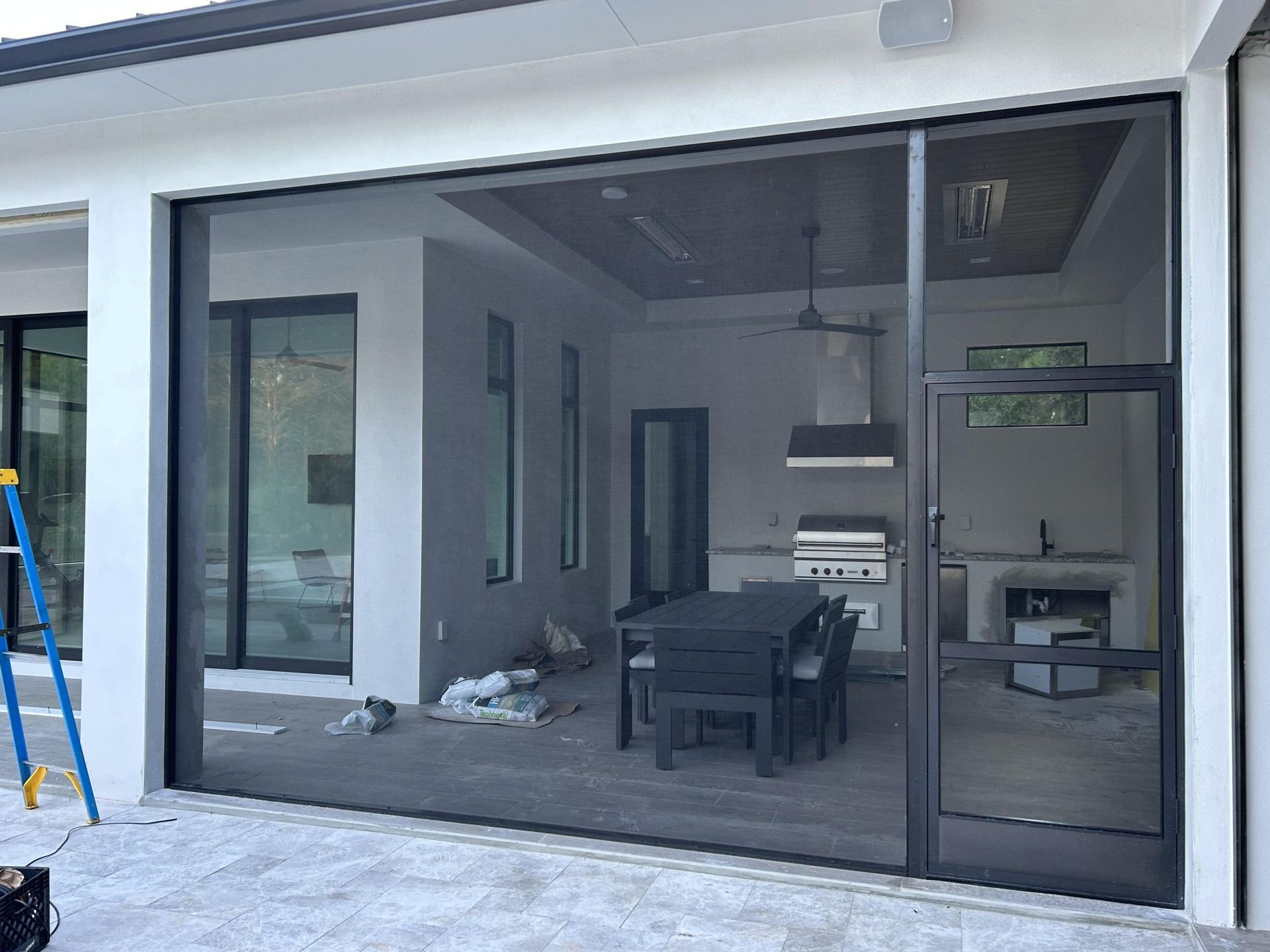 A sliding screen door leading to a dining room with a table and chairs