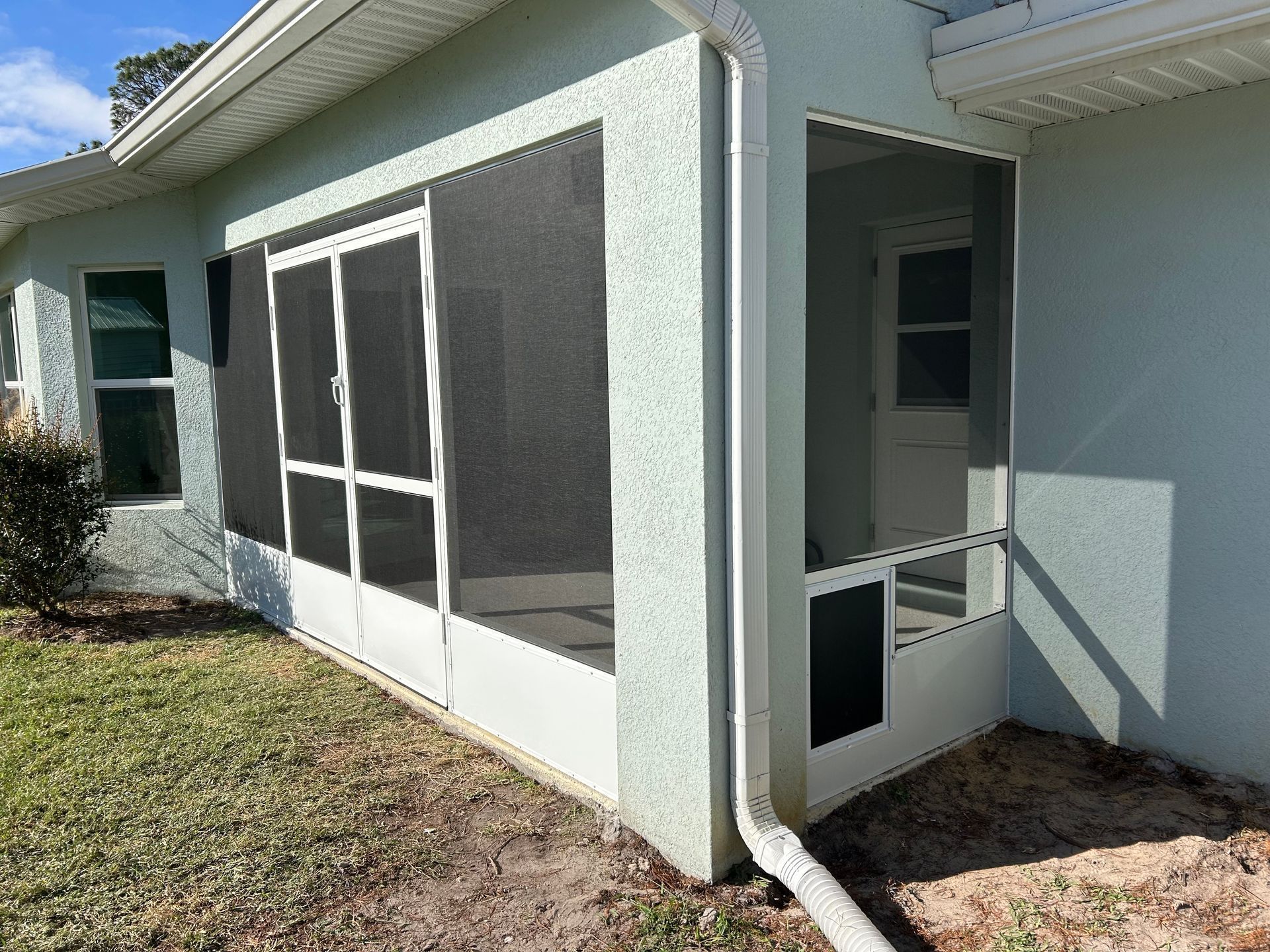 A screened in porch on the side of a house