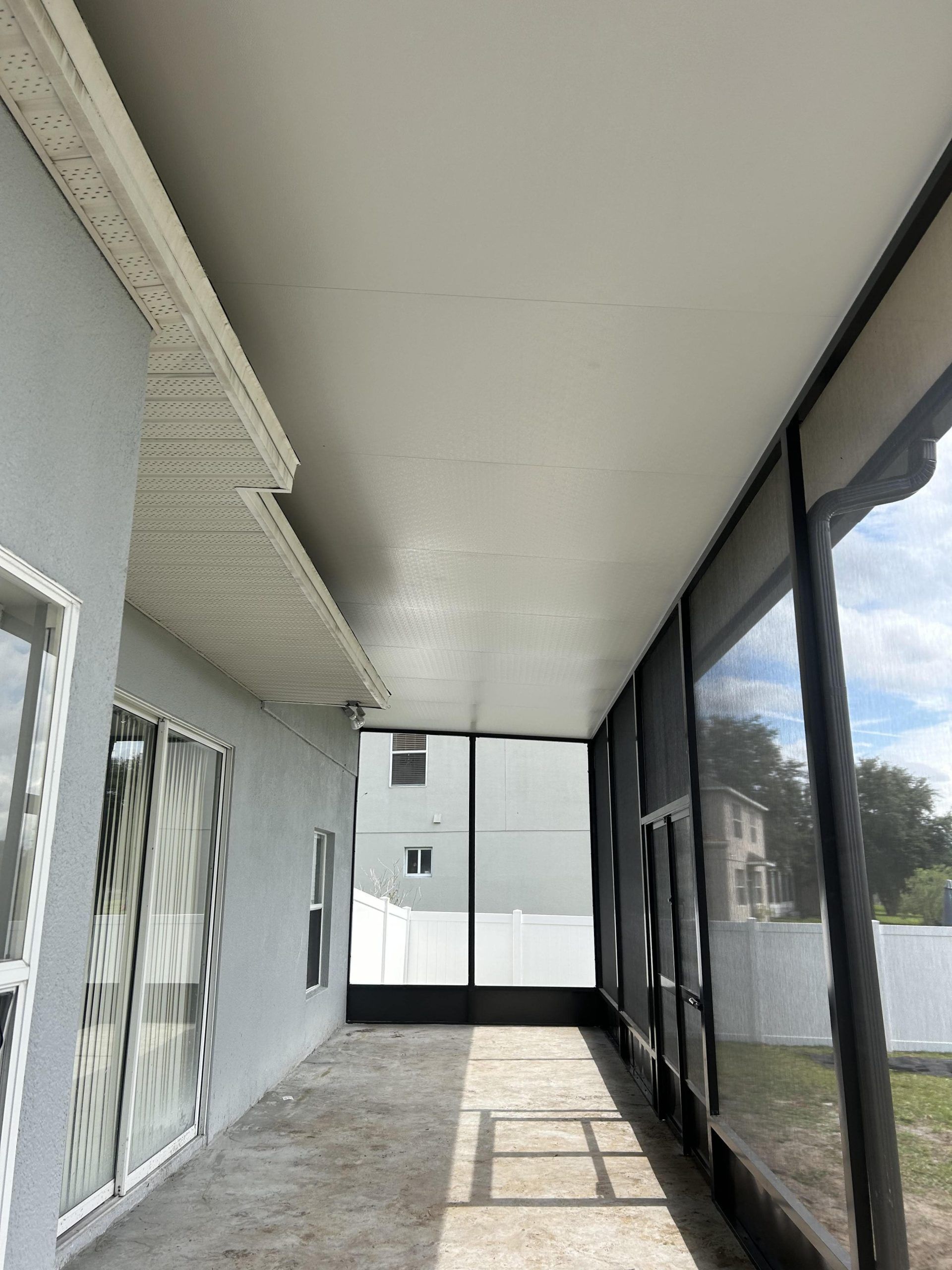 A screened in porch with a lot of windows and a ceiling