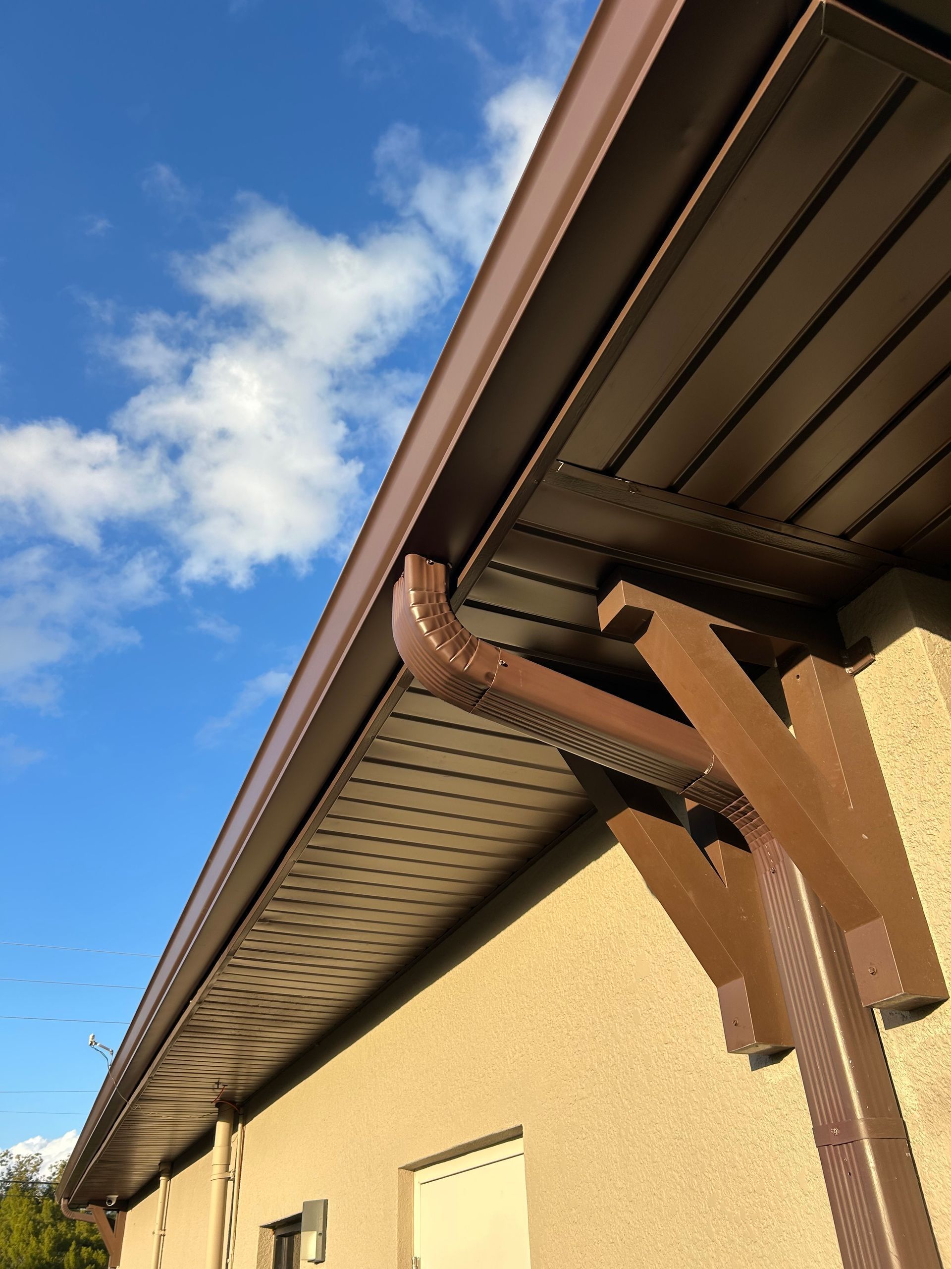 A brown gutter on the side of a building