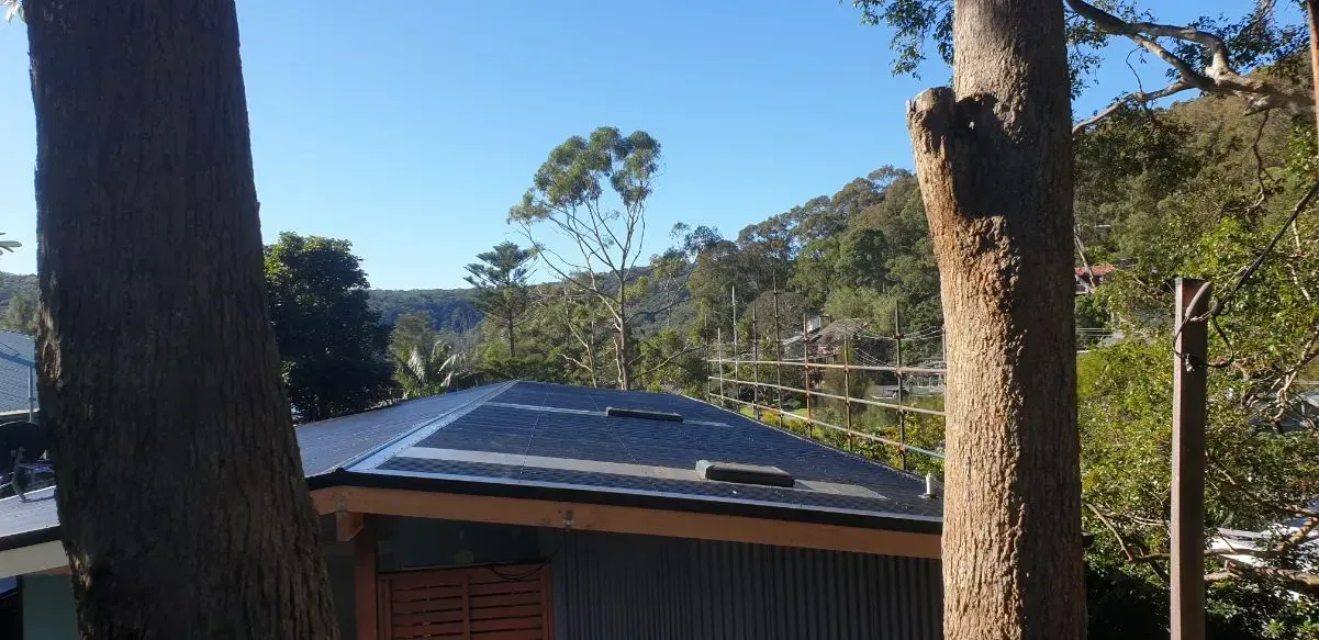 There Are Two Solar Panels on the Roof of a House — Coast Metal Roof & Gutter In Tumbi Umbi, NSW
