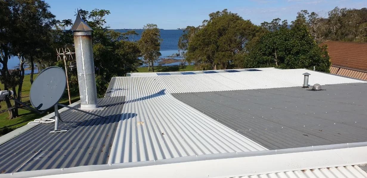 A Roof With a Satellite Dish on It and a Chimney — Coast Metal Roof & Gutter In Tumbi Umbi, NSW