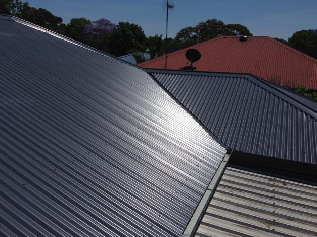 A White Gutter is on the Side of a Brick House — Coast Metal Roof & Gutter In Tumbi Umbi, NSW