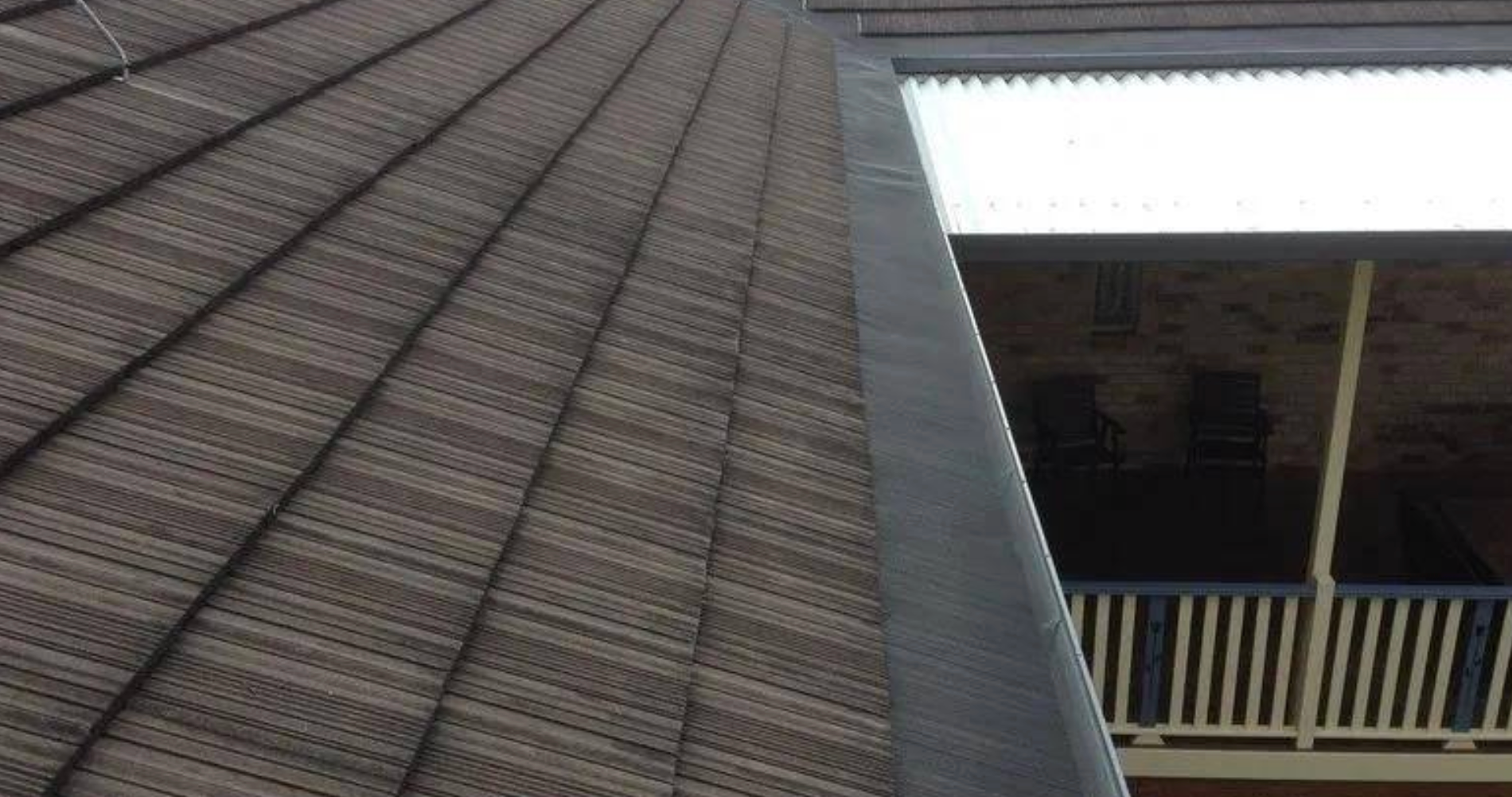 A Yellow Leaf is Sitting on Top of a Gutter on a Roof — Coast Metal Roof & Gutter In Tumbi Umbi, NSW