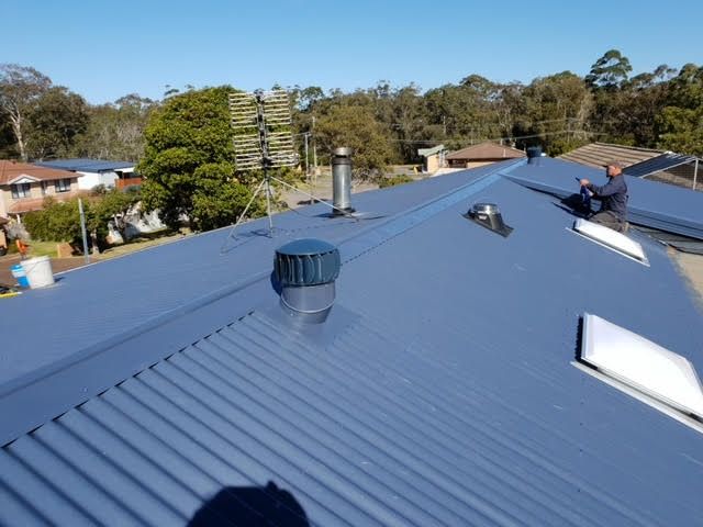 The Roof of a Building With a Field in the Background — Coast Metal Roof & Gutter In Tumbi Umbi, NSW