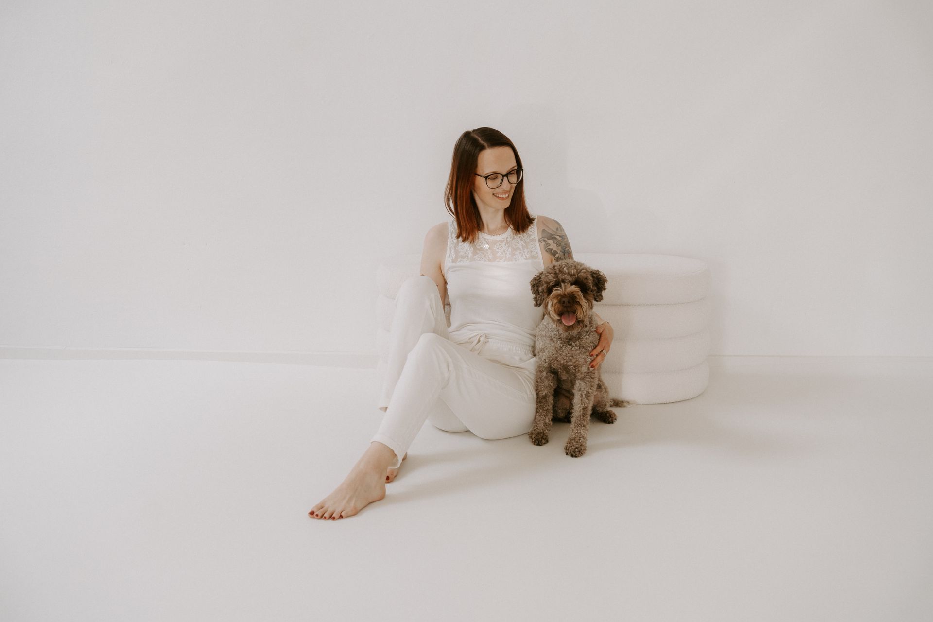 Portrait von Nadine und Inji, beide sitzend auf dem Boden vor weißem Studiosetting.