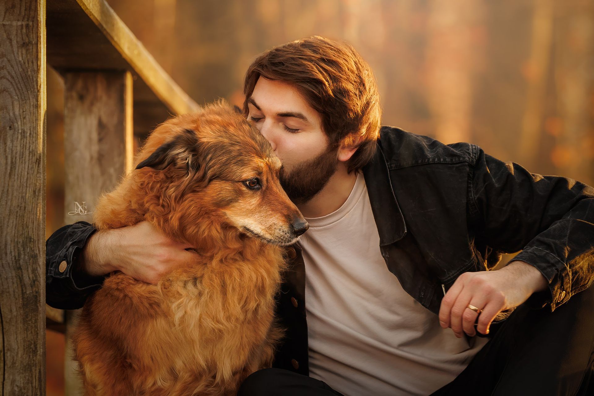 Mann umarmt seinen Golden Retriever Mischling und küsst sie.