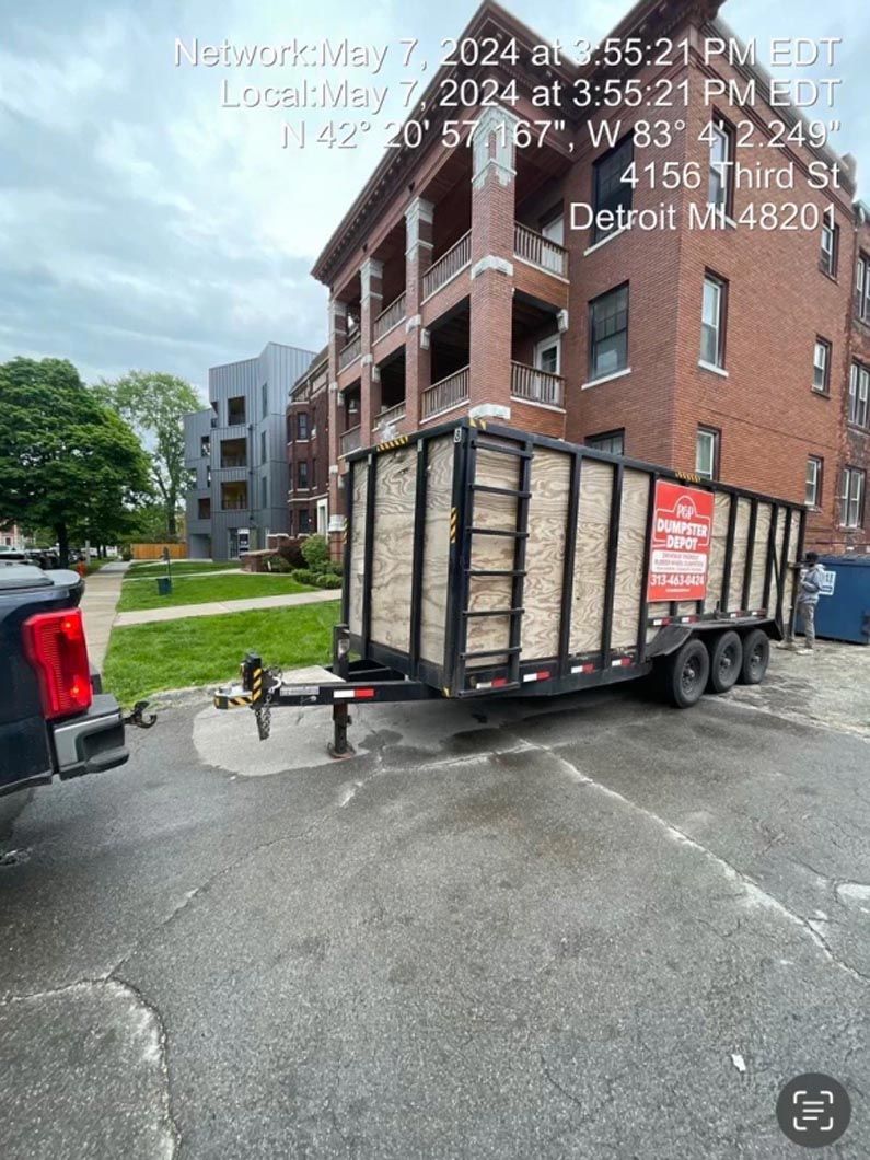 A large trailer parked near a brick apartment building in Detroit.