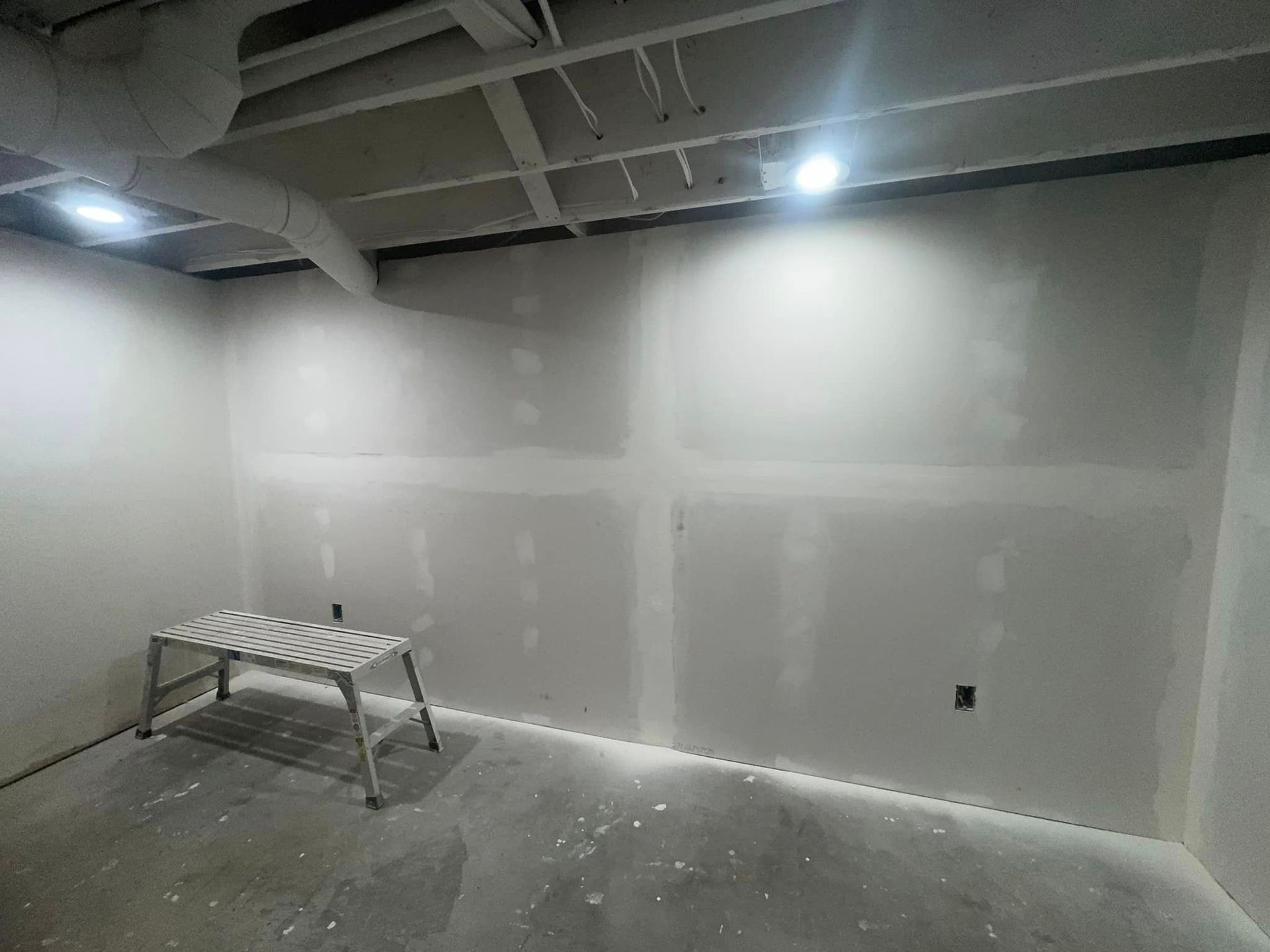 A room with drywall walls and a workbench in it.