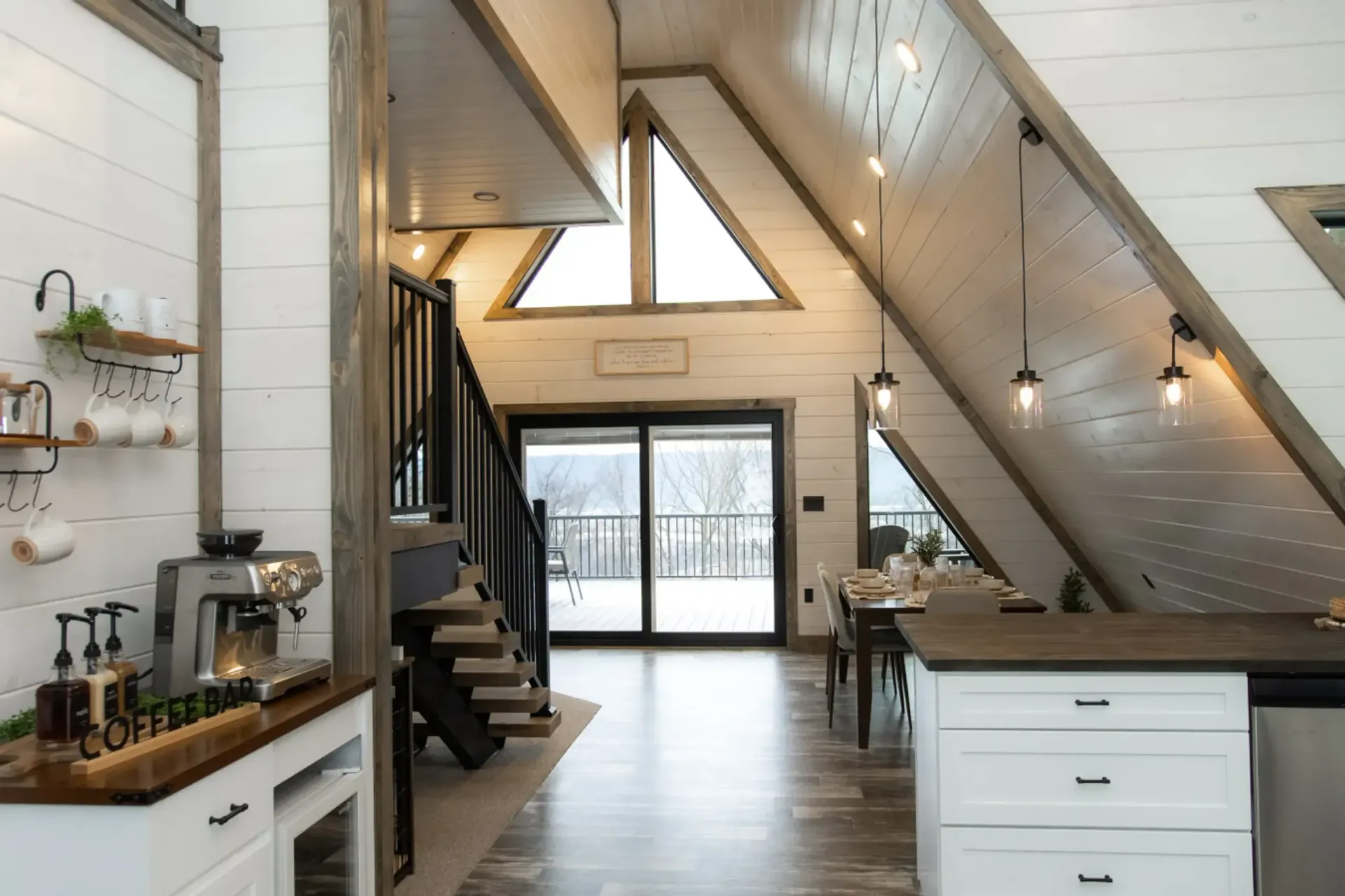 Attic room with wood-paneled wall, three windows, and a gray rug on a light wooden floor. | Rebuck, PA | Expressions Carpentry
