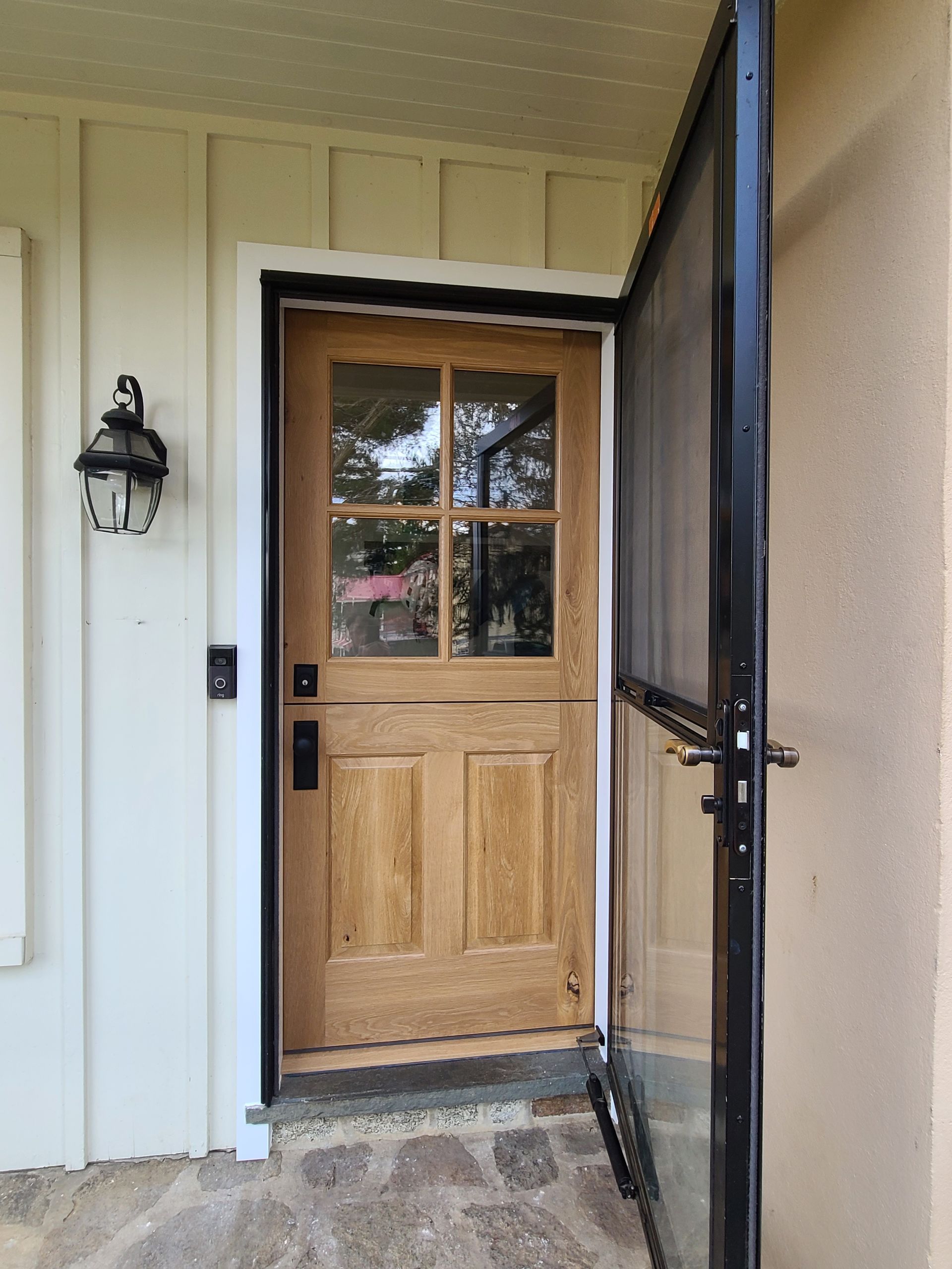 A sliding barn door is hanging on a white wall in a room.