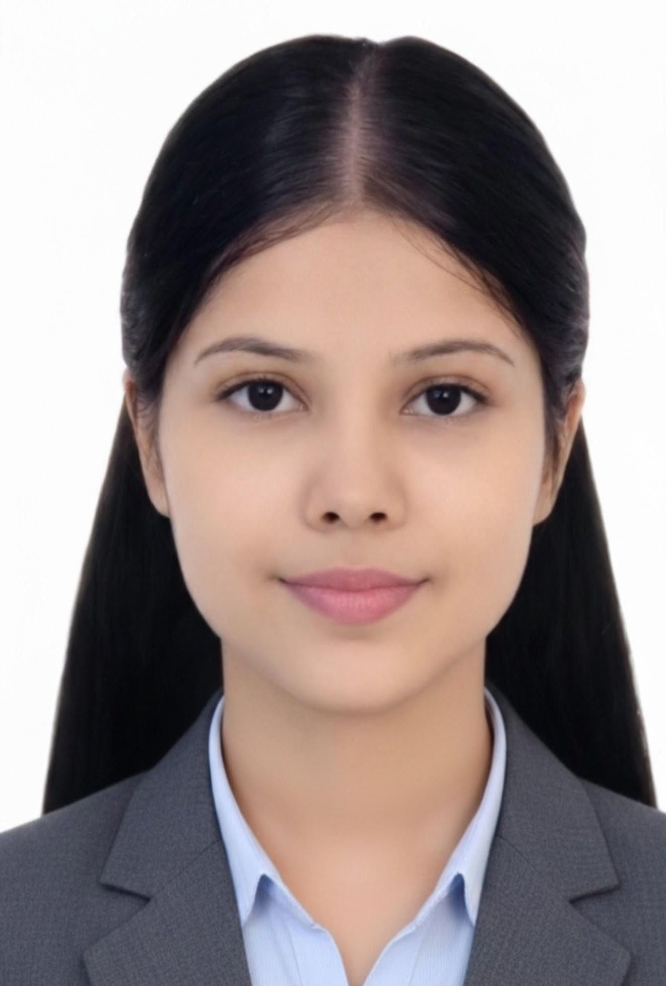Woman with curly brown hair, wearing a white shirt and black blazer, smiling at the camera.
